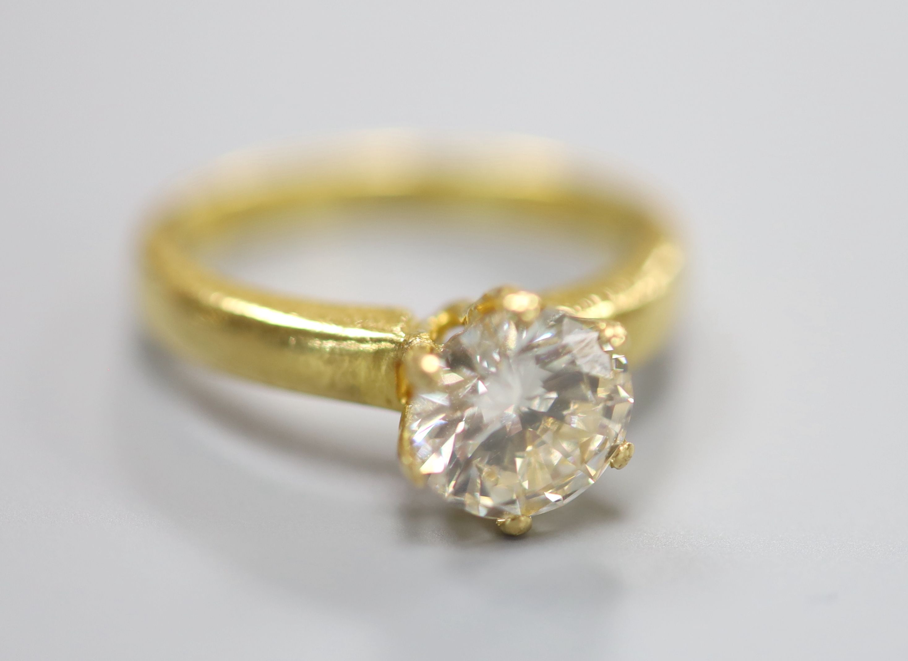 A yellow metal and solitaire diamond ring.